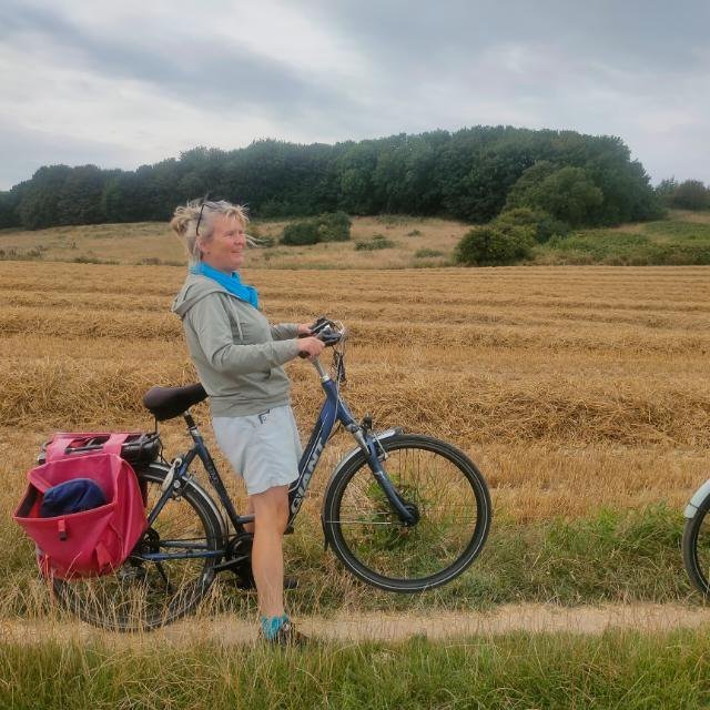 Jacqueline van Noordenne met haar fiets langs een akker