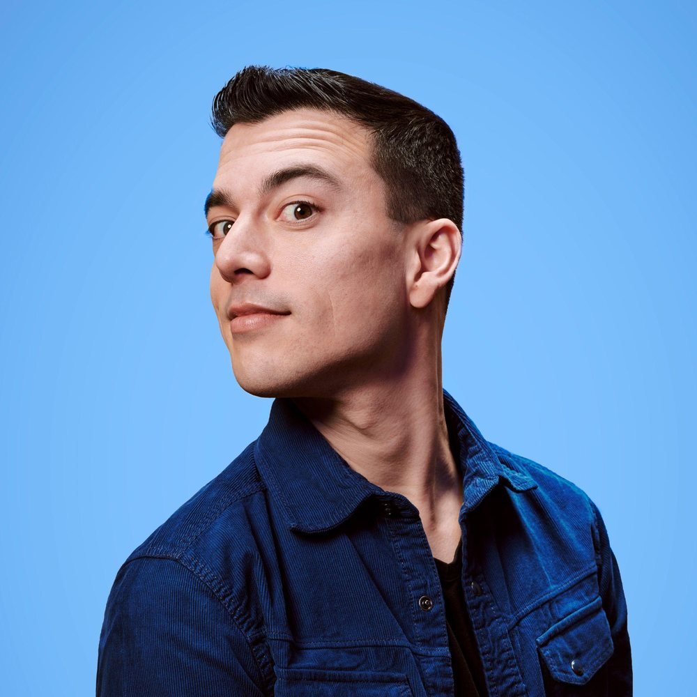 Portret van cabaretier Andries Tunru tegen een blauwe achtergrond